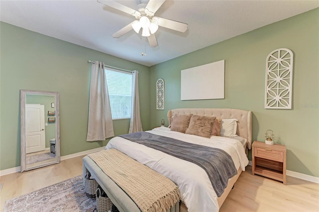 bedroom with a ceiling fan, baseboards, and wood finished floors