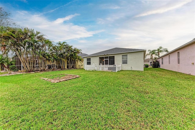 back of property featuring a yard and stucco siding