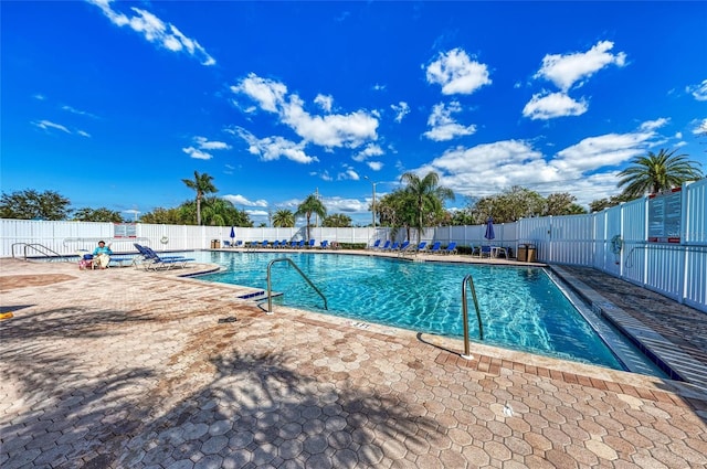 community pool with fence and a patio