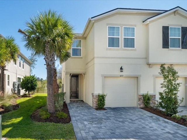 view of front of property with stucco siding, decorative driveway, and a garage