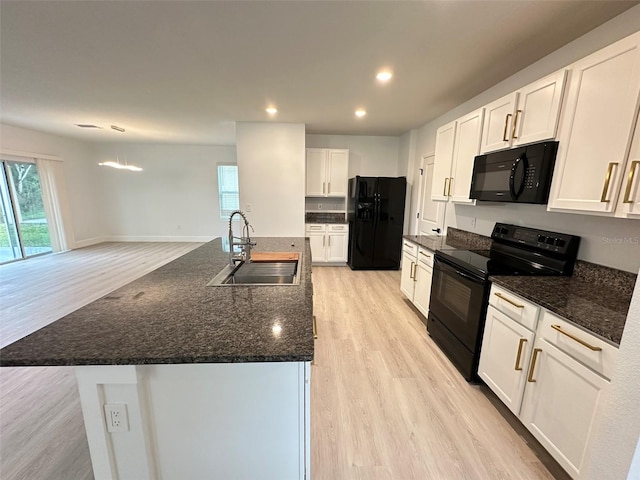 kitchen with recessed lighting, light wood-style floors, white cabinets, a sink, and black appliances