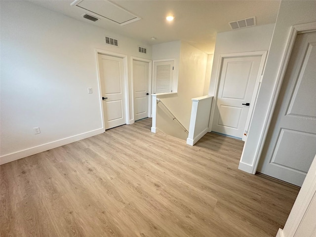 spare room featuring light wood-type flooring, baseboards, and visible vents