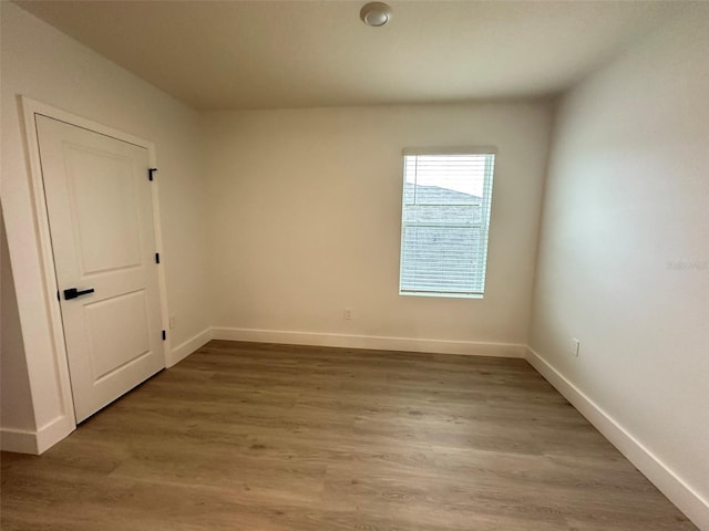 spare room featuring light wood finished floors and baseboards