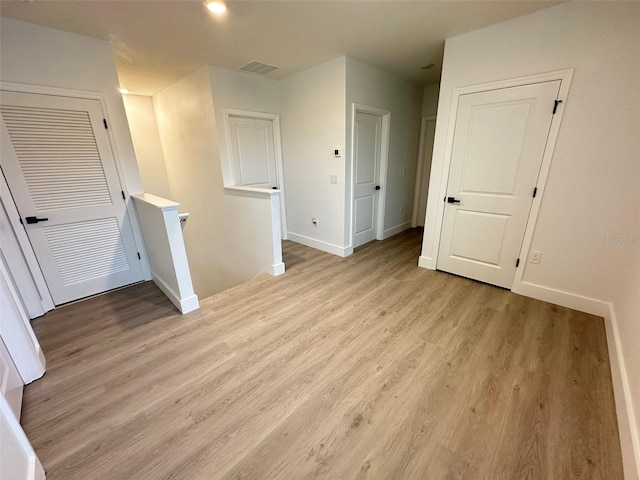 unfurnished room with light wood finished floors, baseboards, and visible vents