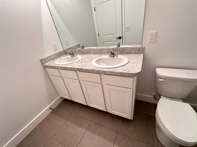 bathroom featuring double vanity, a sink, toilet, and tile patterned floors