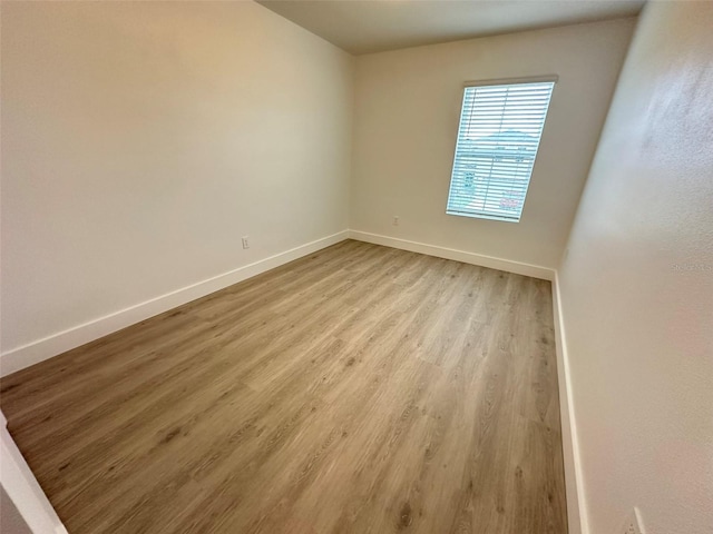 unfurnished room featuring light wood-style flooring and baseboards