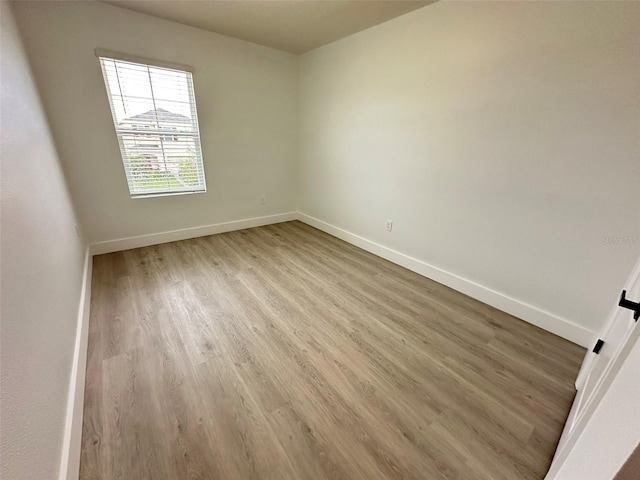 unfurnished room featuring wood finished floors and baseboards