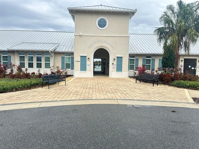 view of front of property featuring a standing seam roof, metal roof, and stucco siding