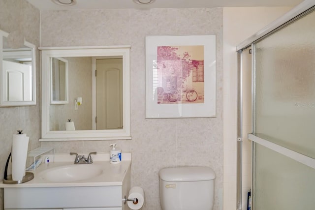 bathroom featuring vanity, an enclosed shower, and toilet