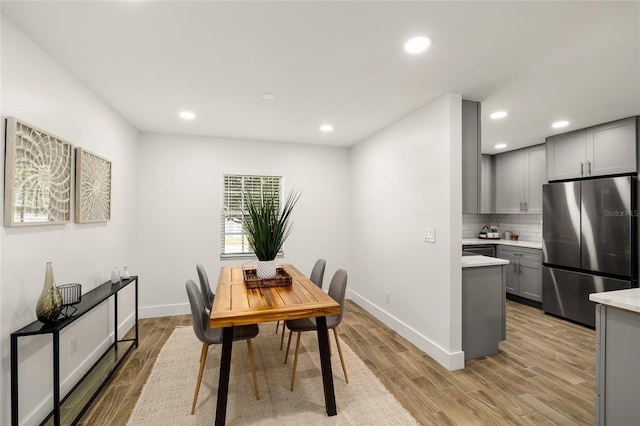 dining area with recessed lighting, light wood-style flooring, and baseboards