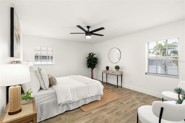 bedroom with ceiling fan, baseboards, and wood finished floors