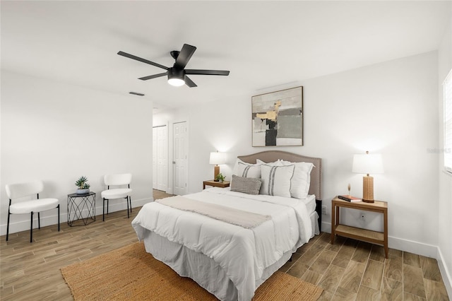 bedroom featuring wood finished floors, visible vents, and baseboards