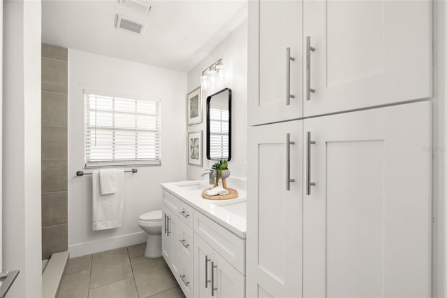 bathroom featuring tile patterned flooring, toilet, a sink, visible vents, and double vanity