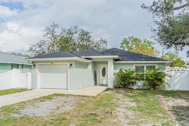 ranch-style house with a garage, fence, concrete driveway, a gate, and stucco siding