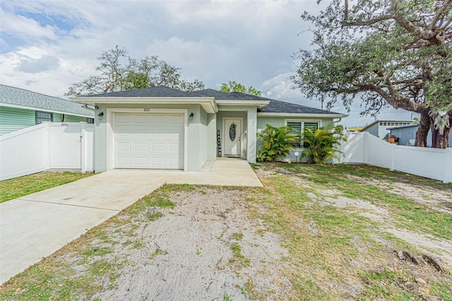 view of front of house with an attached garage, fence, driveway, and stucco siding