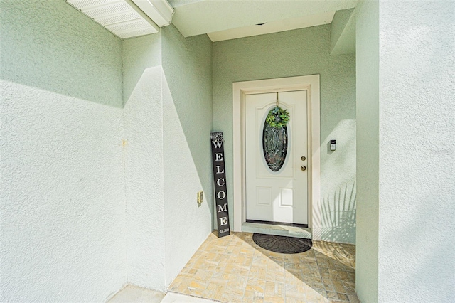 property entrance with stucco siding