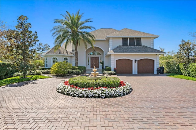 view of front of home with decorative driveway and stucco siding