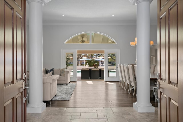 foyer entrance featuring ornate columns and stone tile flooring