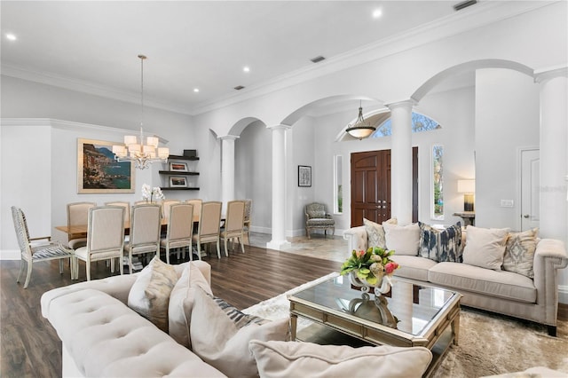 living area featuring baseboards, ornamental molding, wood finished floors, ornate columns, and a chandelier