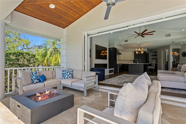 view of patio featuring visible vents, a ceiling fan, and an outdoor living space with a fire pit