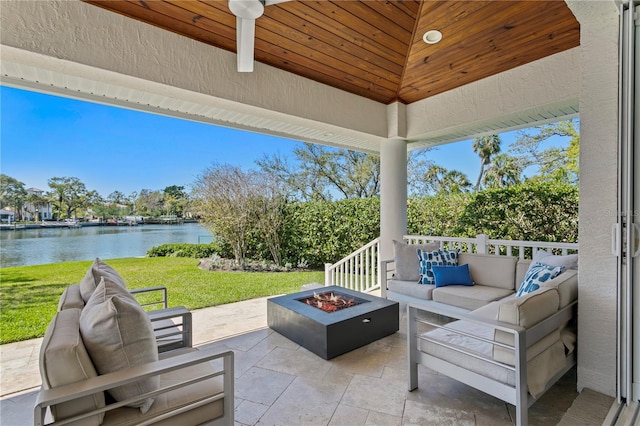 view of patio featuring a water view and an outdoor living space with a fire pit