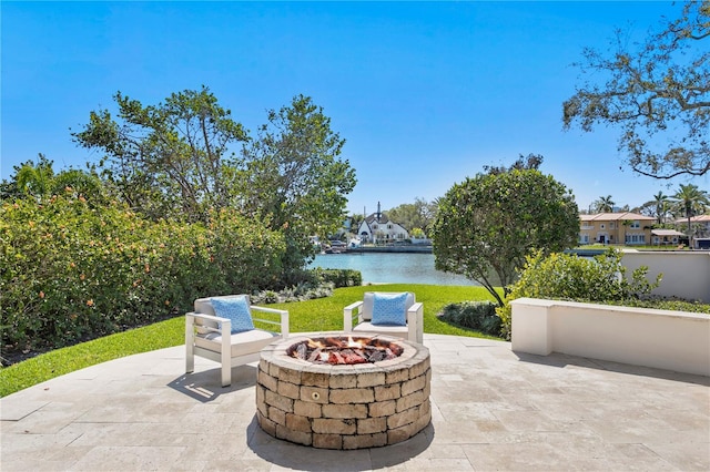 view of patio / terrace with an outdoor fire pit and a water view