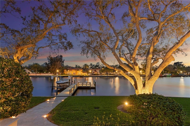 view of dock featuring a yard, a water view, and boat lift