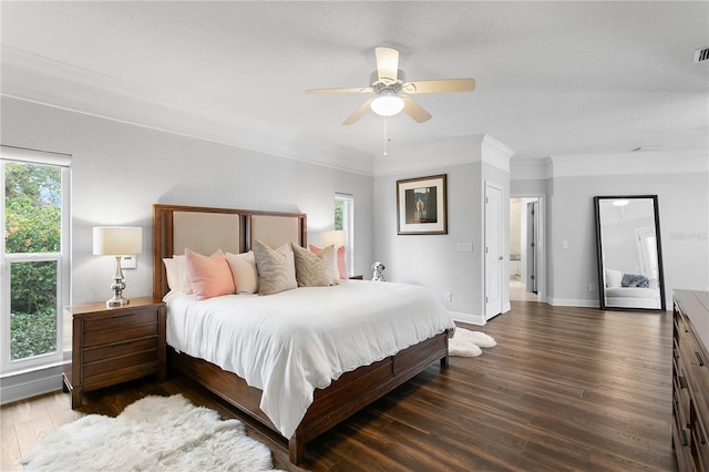 bedroom with crown molding, ceiling fan, wood finished floors, and baseboards