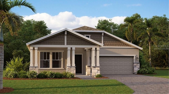 craftsman-style house featuring decorative driveway, stucco siding, a garage, stone siding, and a front lawn