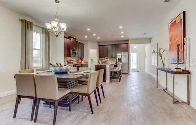 dining space featuring light wood-type flooring, a wealth of natural light, and baseboards