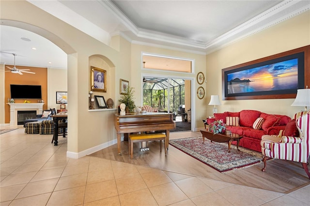 sitting room with light tile patterned floors, baseboards, a ceiling fan, and a fireplace