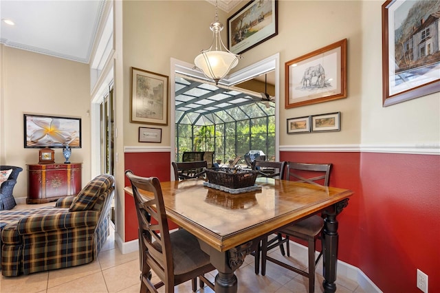 dining space featuring light tile patterned floors, baseboards, a sunroom, and ornamental molding