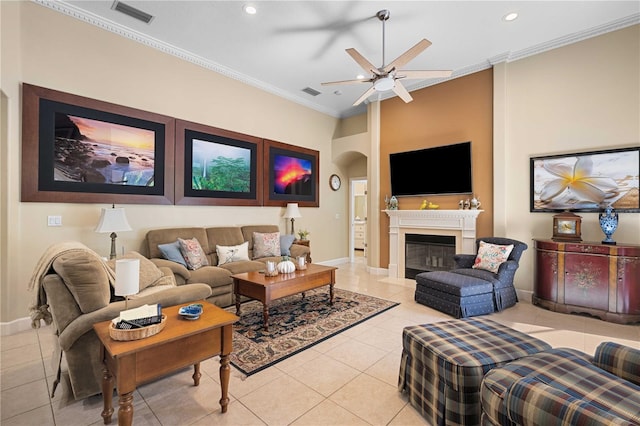 living area featuring crown molding, light tile patterned flooring, a fireplace, and visible vents