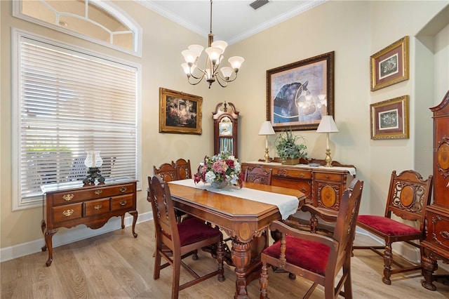 dining area featuring a chandelier, baseboards, light wood-style floors, and ornamental molding