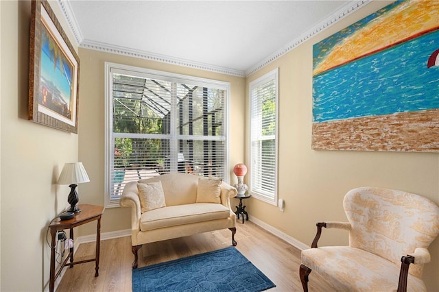 living area with ornamental molding, baseboards, and wood finished floors