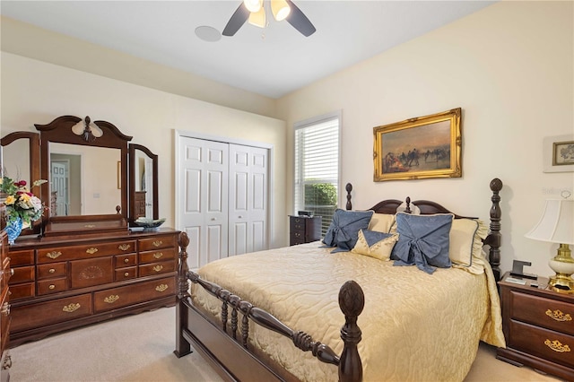 bedroom featuring light carpet, ceiling fan, and a closet