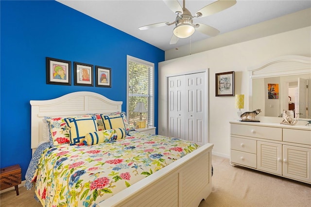 bedroom featuring a closet, light colored carpet, baseboards, and a ceiling fan