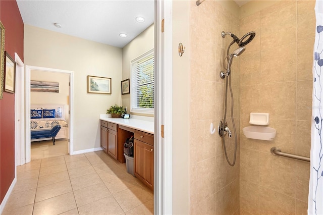 bathroom with vanity, baseboards, tiled shower, tile patterned flooring, and ensuite bathroom