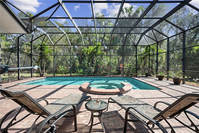 view of swimming pool with glass enclosure, a patio, and a pool with connected hot tub