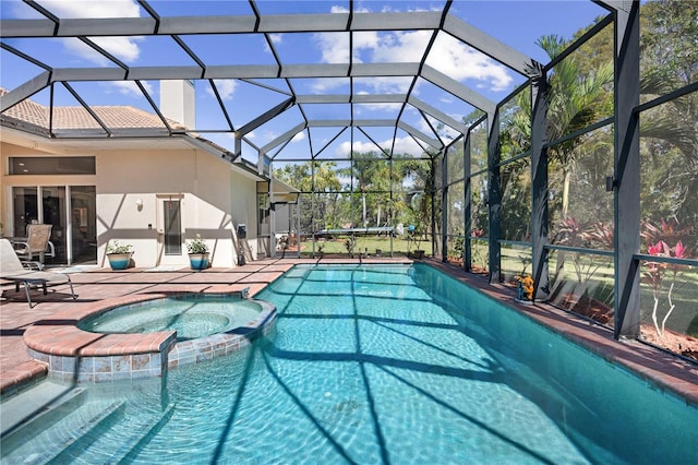 view of pool with a patio, a lanai, and a pool with connected hot tub