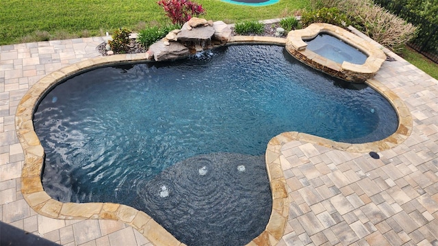 outdoor pool featuring an in ground hot tub