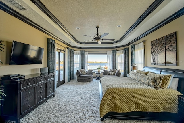 carpeted bedroom with visible vents, crown molding, a textured ceiling, a raised ceiling, and a ceiling fan