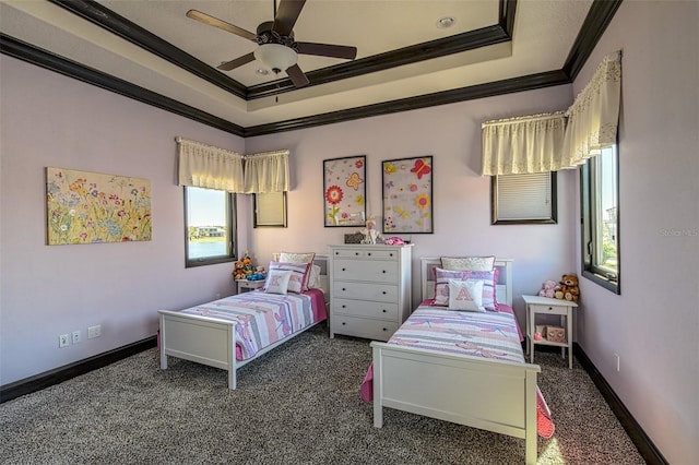 bedroom featuring a tray ceiling, carpet flooring, baseboards, and crown molding