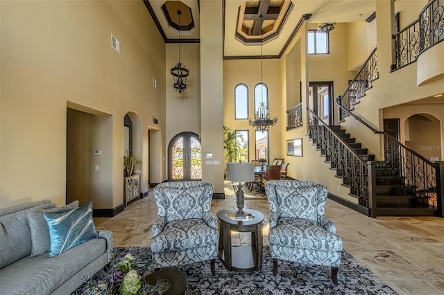 living room with visible vents, baseboards, stairs, ornamental molding, and arched walkways