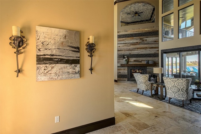 hall featuring stone finish flooring and baseboards