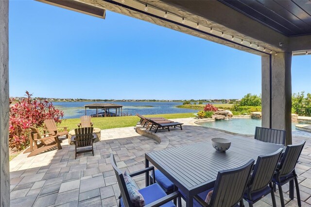 view of patio featuring outdoor dining area, an outdoor pool, and a water view