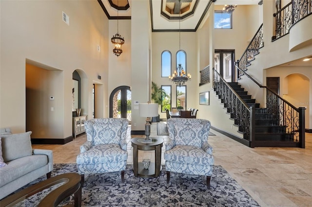 interior space featuring a towering ceiling, an inviting chandelier, arched walkways, baseboards, and stairs