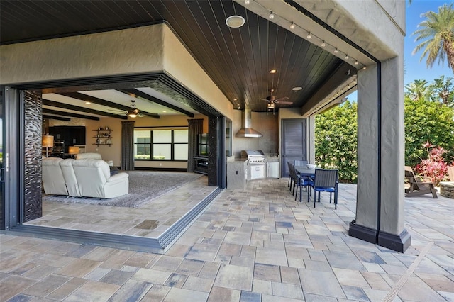 view of patio / terrace with outdoor dining area, an outdoor kitchen, a ceiling fan, and area for grilling