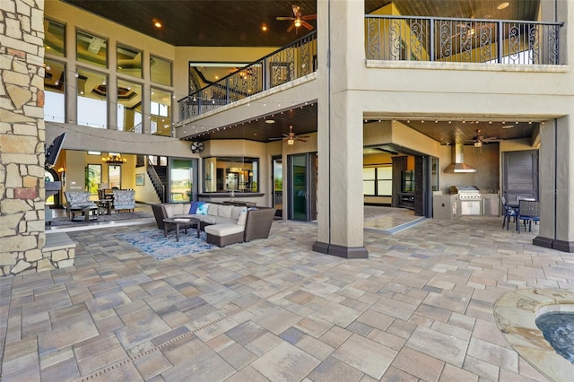 view of patio with a ceiling fan, an outdoor kitchen, and a balcony