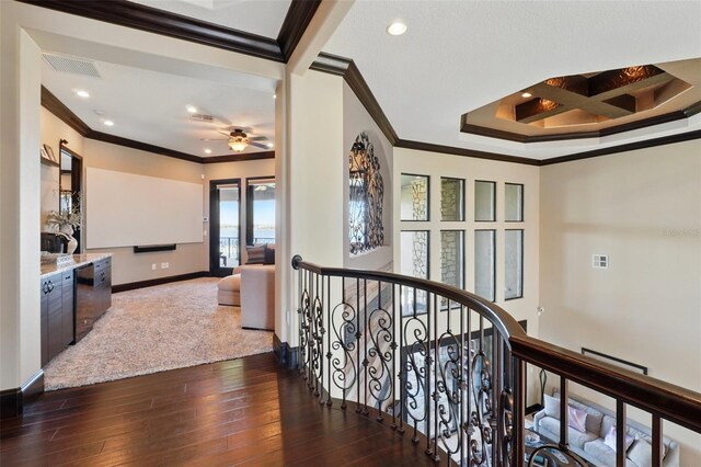 hallway featuring an upstairs landing, dark wood finished floors, baseboards, ornamental molding, and recessed lighting
